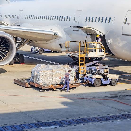 Cargo pallets beside aircraft and airport freight terminal ground handling